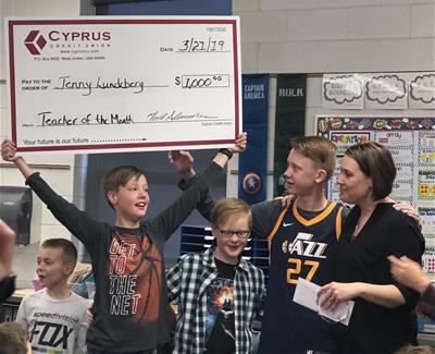 Student holding large check with teacher